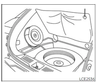 Spare tire retaining bolt being loosened in Nissan Murano cargo compartment