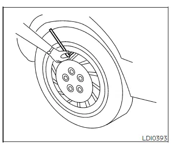 Tire pressure gauge positioned squarely on a Nissan Murano tire valve stem